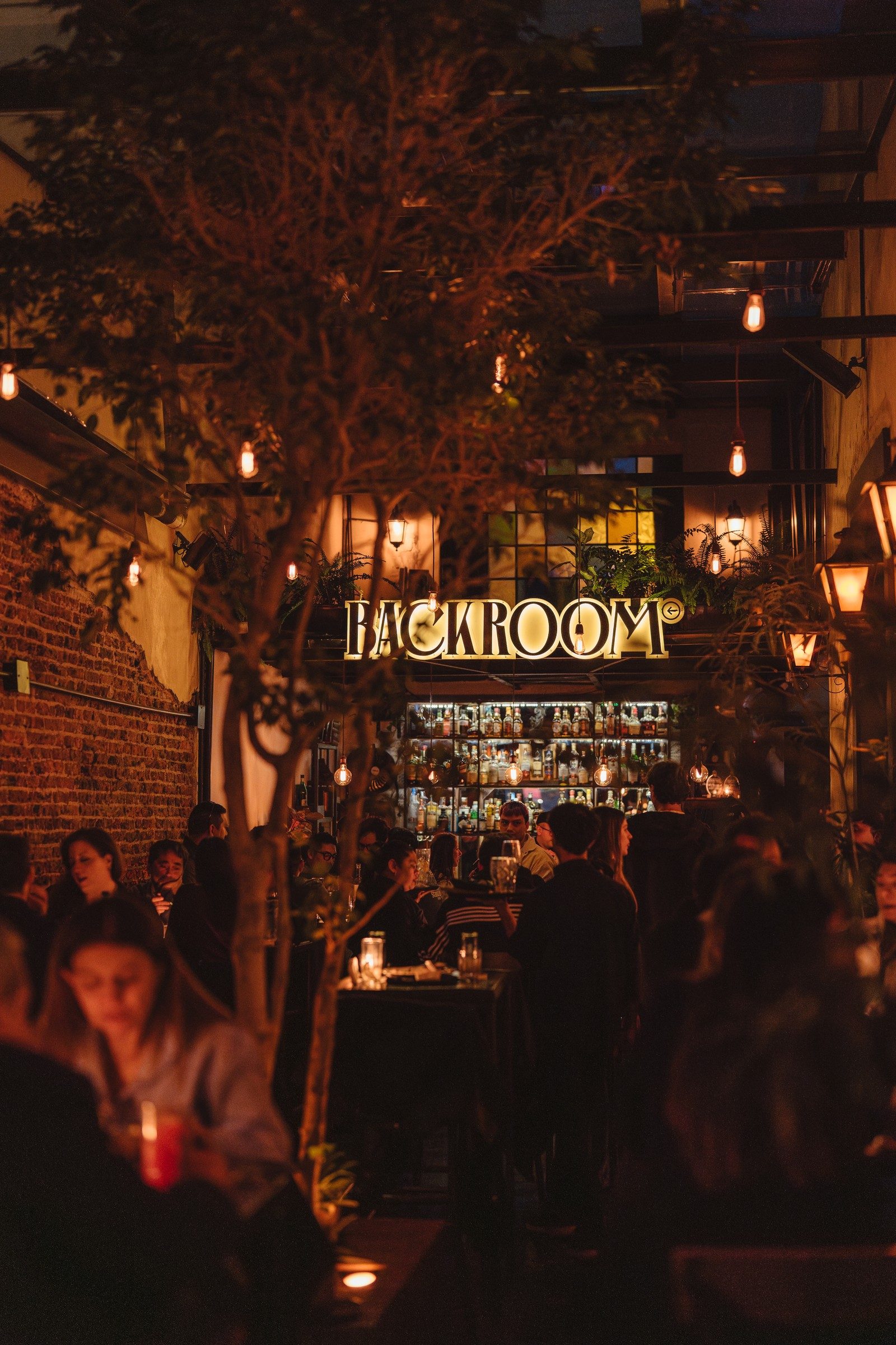 El patio de Backroom en Palermo de noche, lleno de gente