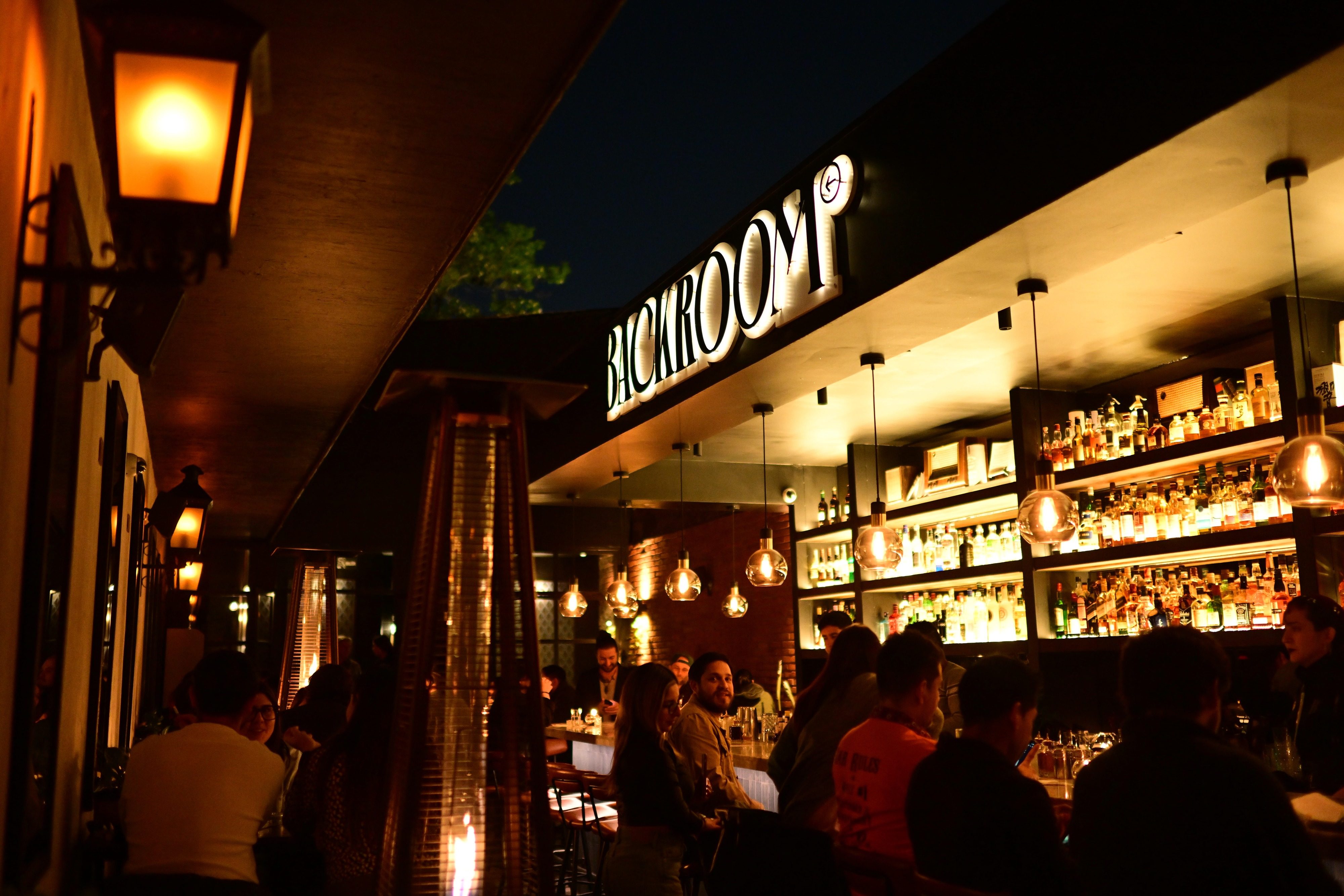 La barra de Backroom Santiago con el cartel iluminado y el salón lleno